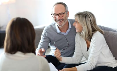 Couple propriétaire discutant estimation du loyer avec agent immobilier